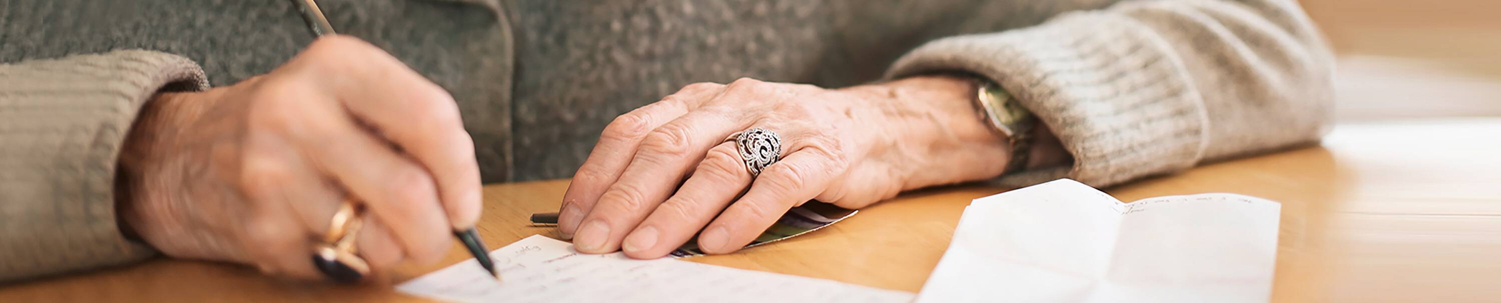 Ausschnitt von Hände einer alten Dame, die ein Brief schreibt